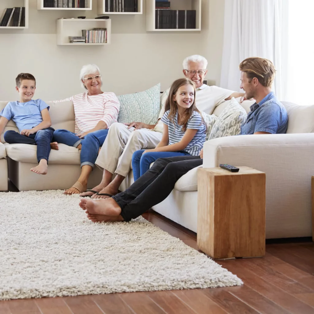 Happy family sitting on sofa | Flooring & Carpets For Less.